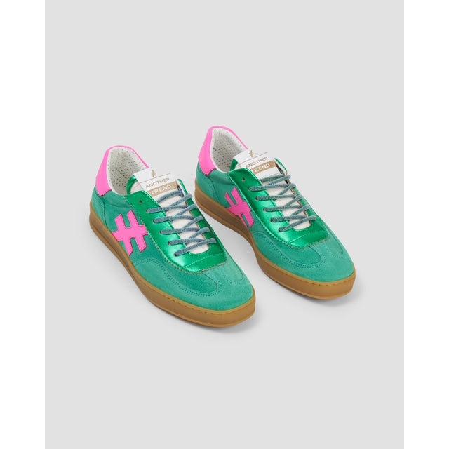 Green suede lace-up trainers with pink logo, beige sole, and metallic laces, featuring Spanish-inspired design and vintage style.