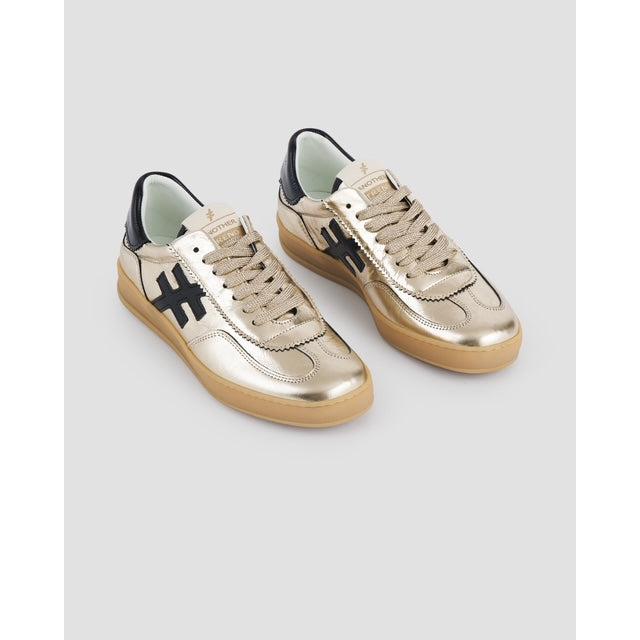 Metallic gold leather lace-up trainers with black accents and beige rubber soles, inspired by Las Vegas style.