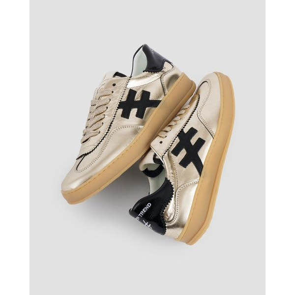 Metallic gold and black leather lace-up trainers with chunky beige soles, stylish trendy design, for women.