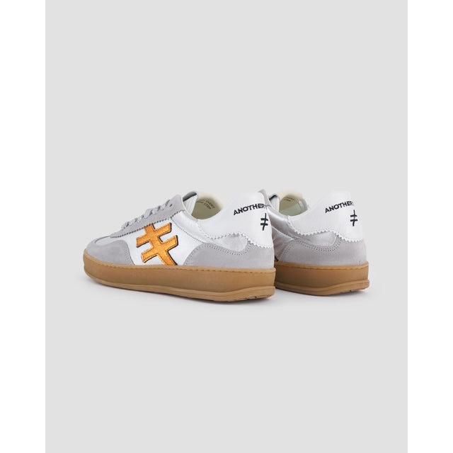 Women's grey leather lace-up trainers with orange accents and gum sole, stylish and comfortable for casual wear.