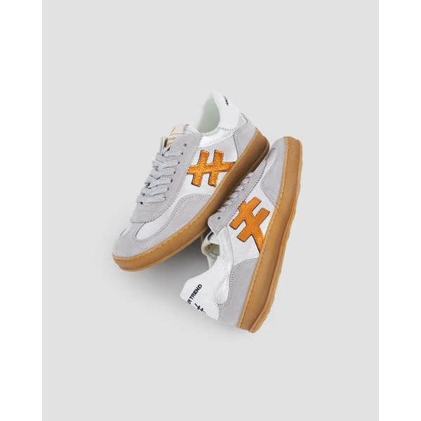 Women's grey leather lace-up trainers with orange logo details and gum soles.