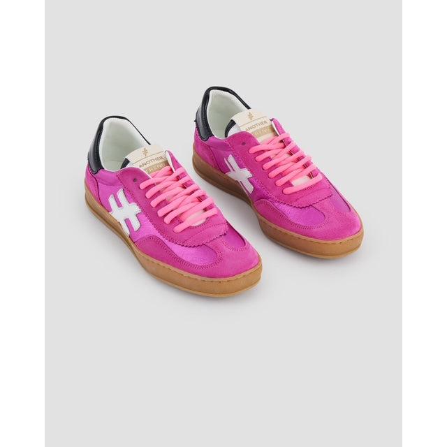 Women’s pink suede lace-up trainers with white cross accents and gum sole, stylish and comfortable casual footwear.
