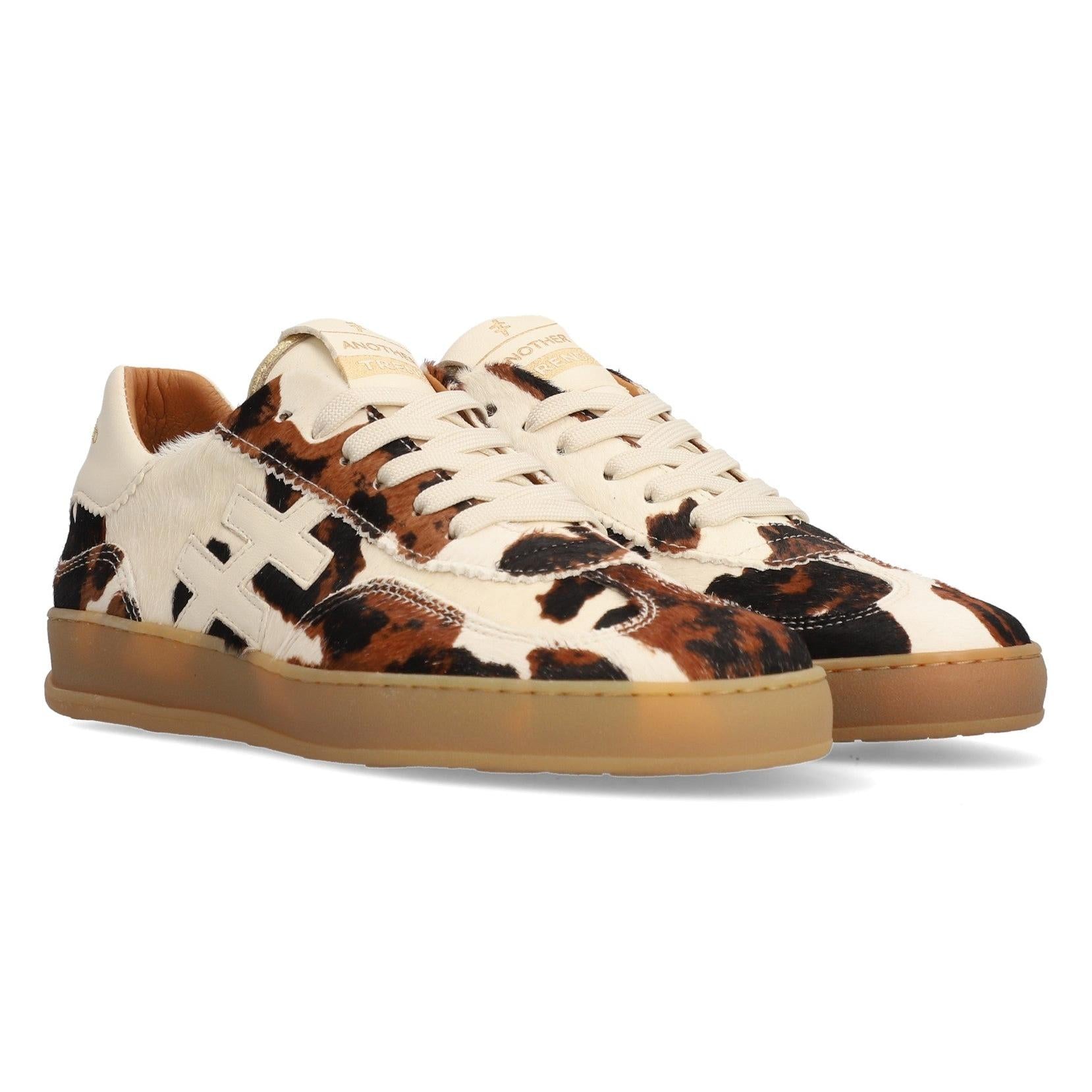 Women's cow print leather lace-up trainers with tan sole, stylish and trendy footwear.