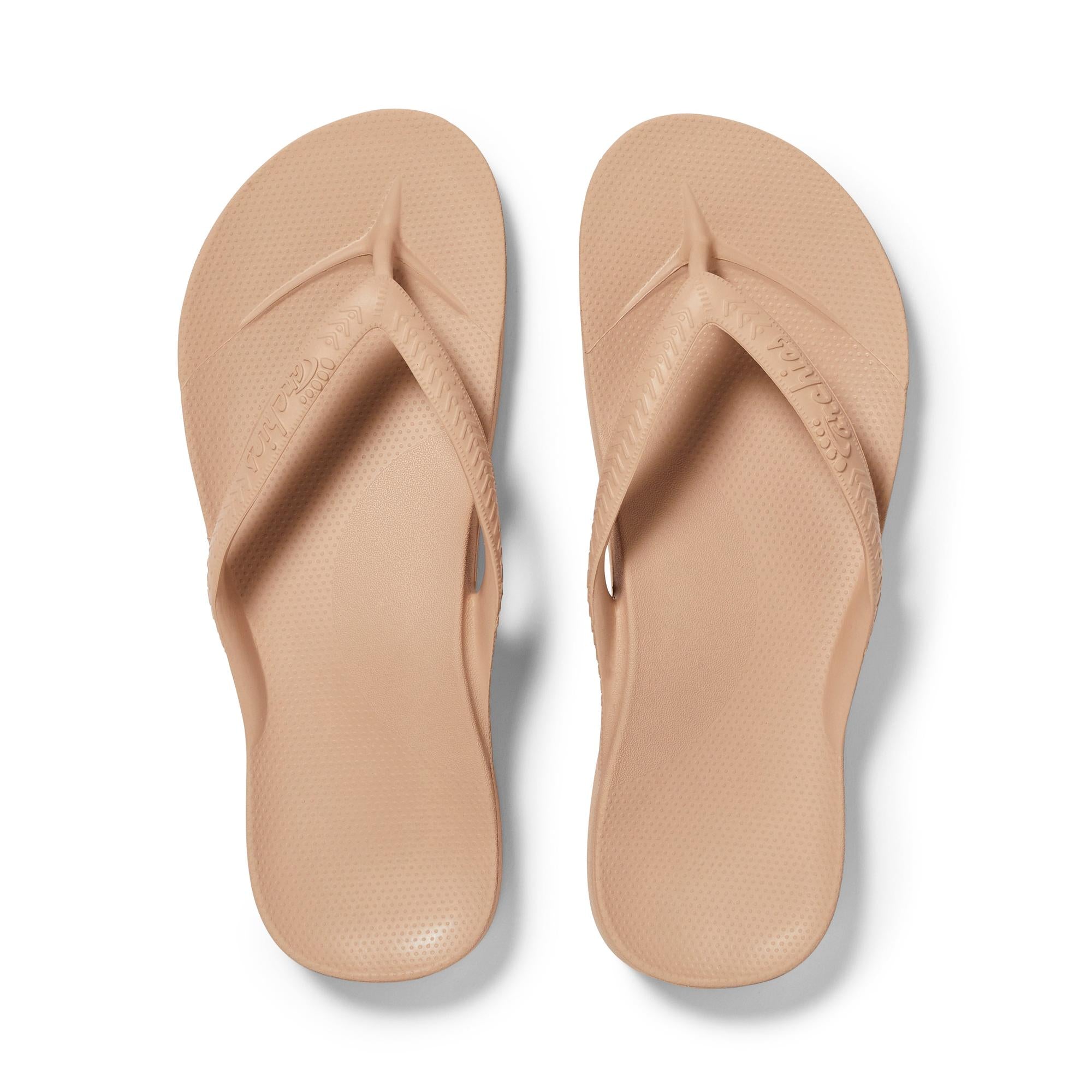 Unisex tan waterproof slip-on sandals with arch support, flip-flop design, and textured footbed for comfort.