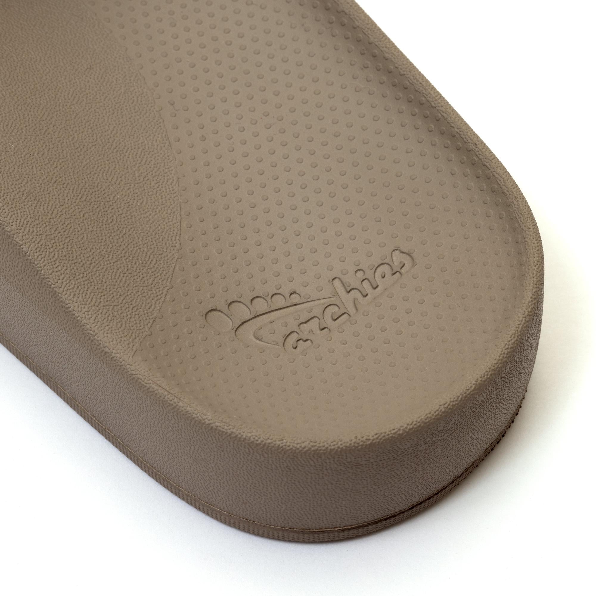 Unisex Taupe waterproof Archies arch support slide sandal with textured footbed and embossed logo.