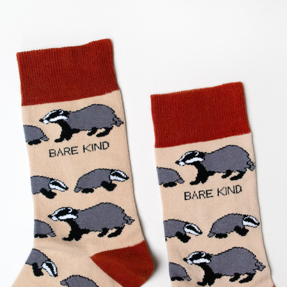 Barekind Save The Badgers bamboo socks with badger pattern, beige background, red top and toe, eco-friendly sustainable hosiery.