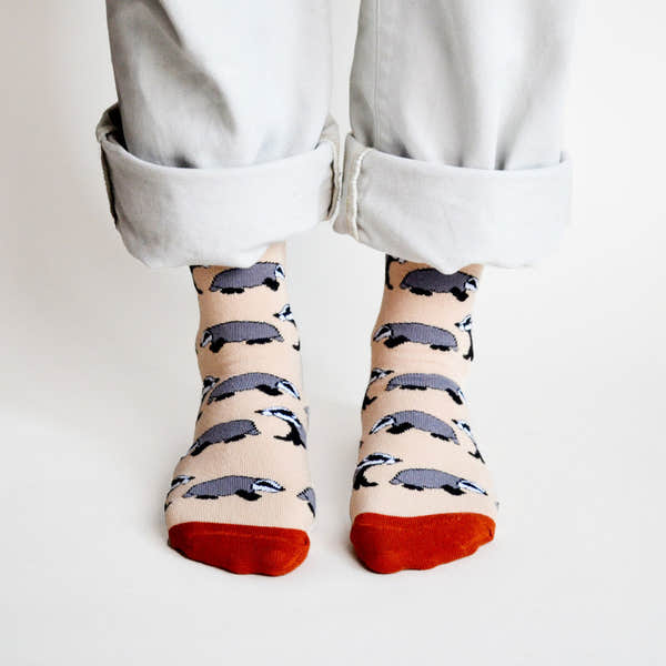 Barekind Save The Badgers bamboo socks with badger pattern, peach background, red toes, worn with rolled-up white pants.