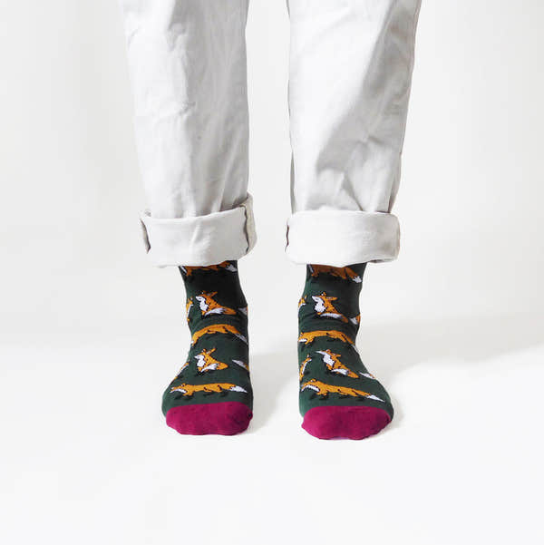 Barekind Save The Foxes Bamboo Socks with fox pattern, green base, and burgundy toes, displayed on person with rolled white jeans.