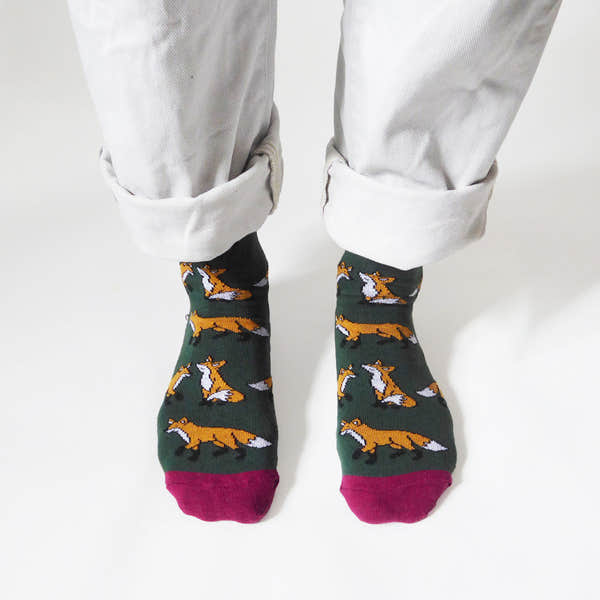 Barekind Save The Foxes bamboo socks with fox pattern, green and pink accents, worn with rolled white pants.