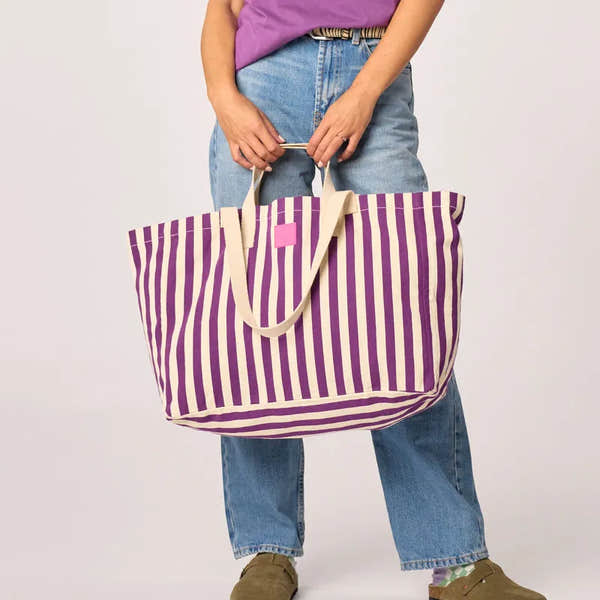Billy Belts organic cotton shopping bag with purple and ecru vertical stripes, large size, casual style, held by a person in jeans.