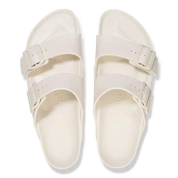 Unisex white Birkenstock Arizona Essentials EVA waterproof slide sandals with arch support and buckles.
