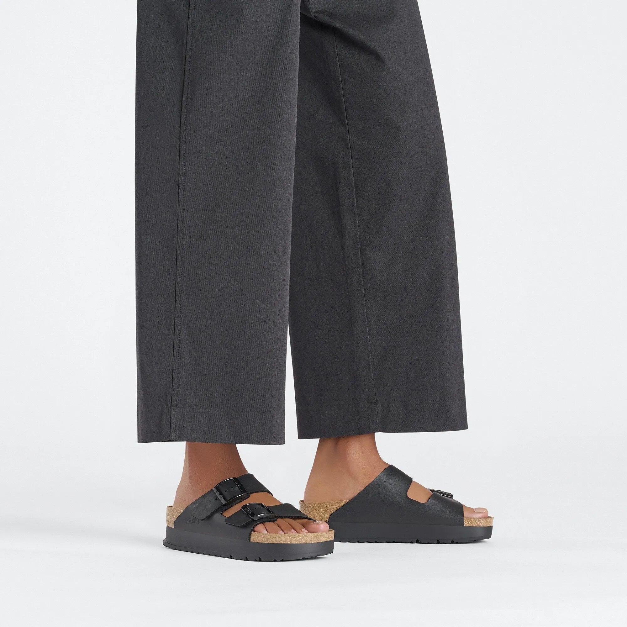 Women's black Birkenstock Papillio Arizona Flex Birkoflor platform sandals with narrow straps, buckle closure, arch support, and cork footbed.