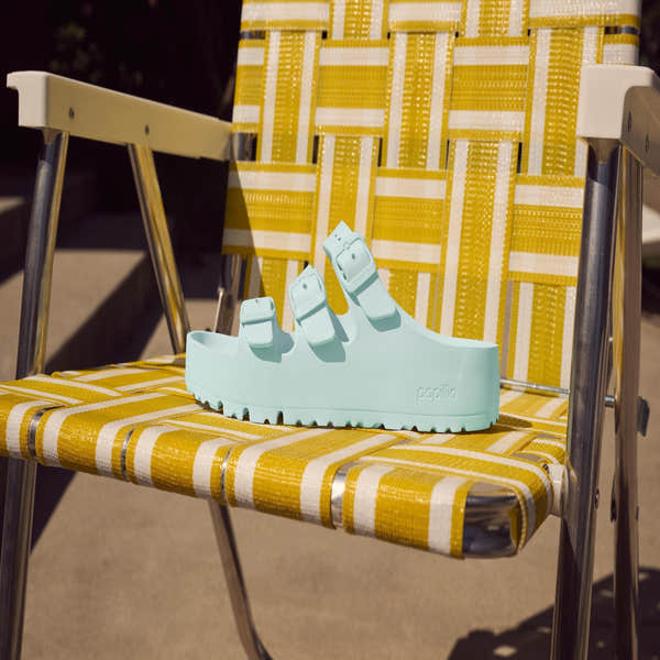 Birkenstock Papillio Florida EVA III Flex platform narrow surf green sandals with arch support and buckle, displayed on a yellow-striped outdoor chair.