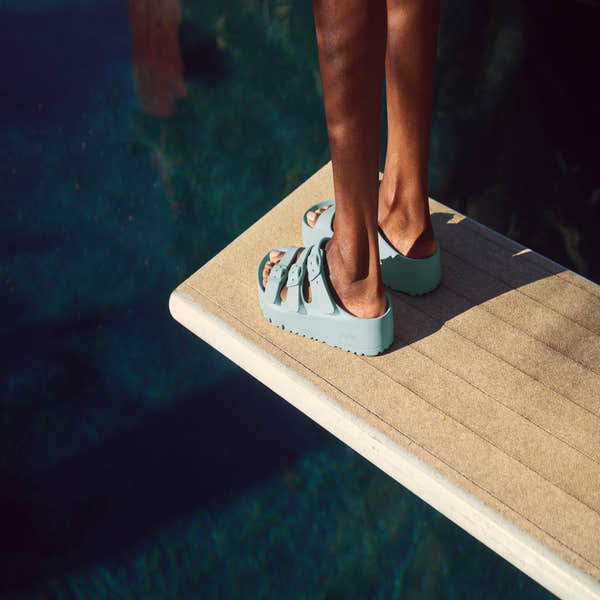 Birkenstock Papillio Florida EVA III Flex platform sandals in surf green with buckles and arch support, worn by a person standing on a wooden dock.