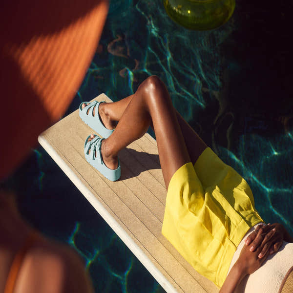 Birkenstock Papillio Florida EVA III Flex Platform sandals in surf green with arch support and buckle, worn by a woman lounging by a pool.