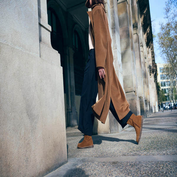Birkenstock Uppsala Shearling Women's Dark Tea Suede Ankle Boots with Side Zip and Arch Support, street scene background.