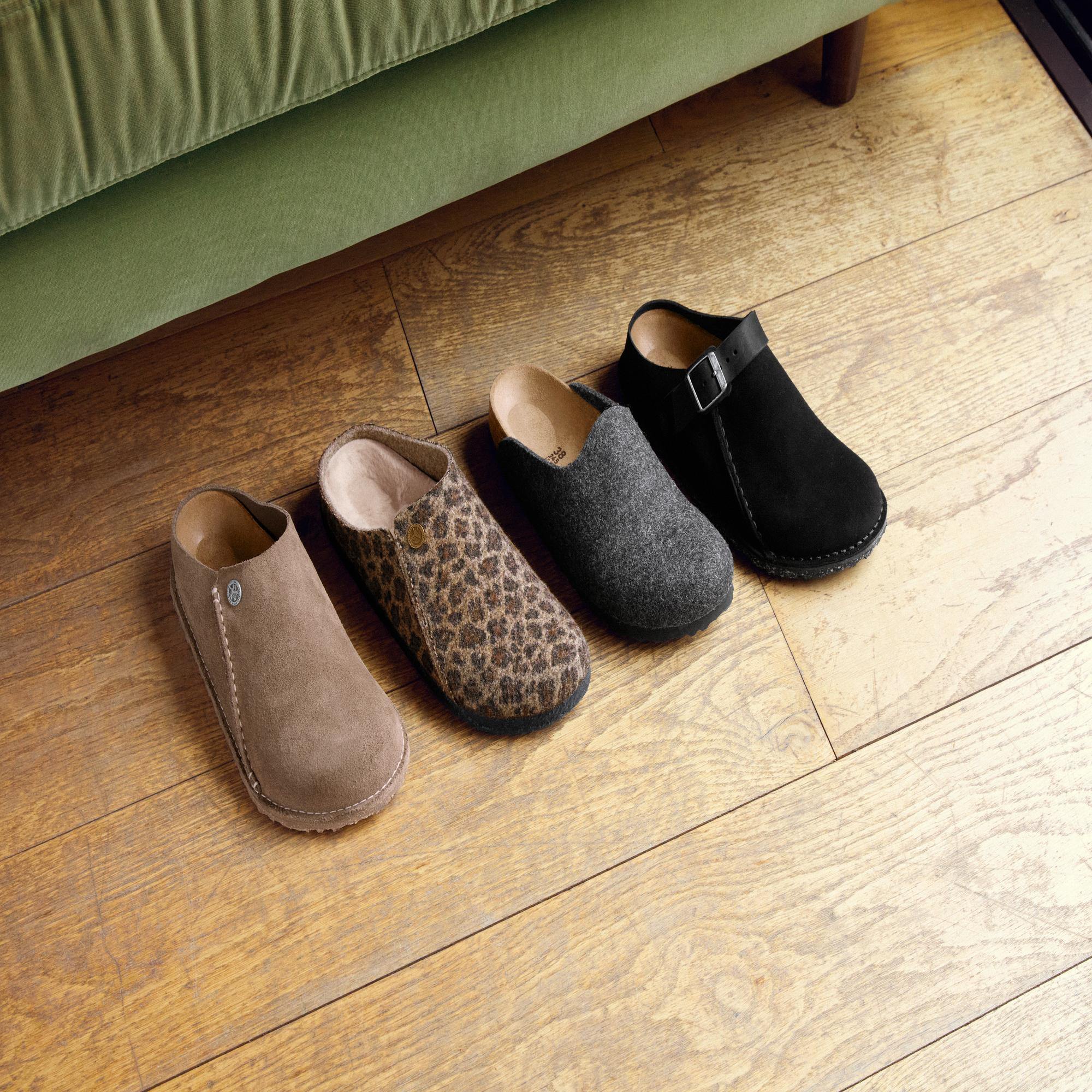 Birkenstock Zermatt Leopard Shearling slip-on mule with arch support, in black, gray, leopard print, and tan colors, on wooden floor.