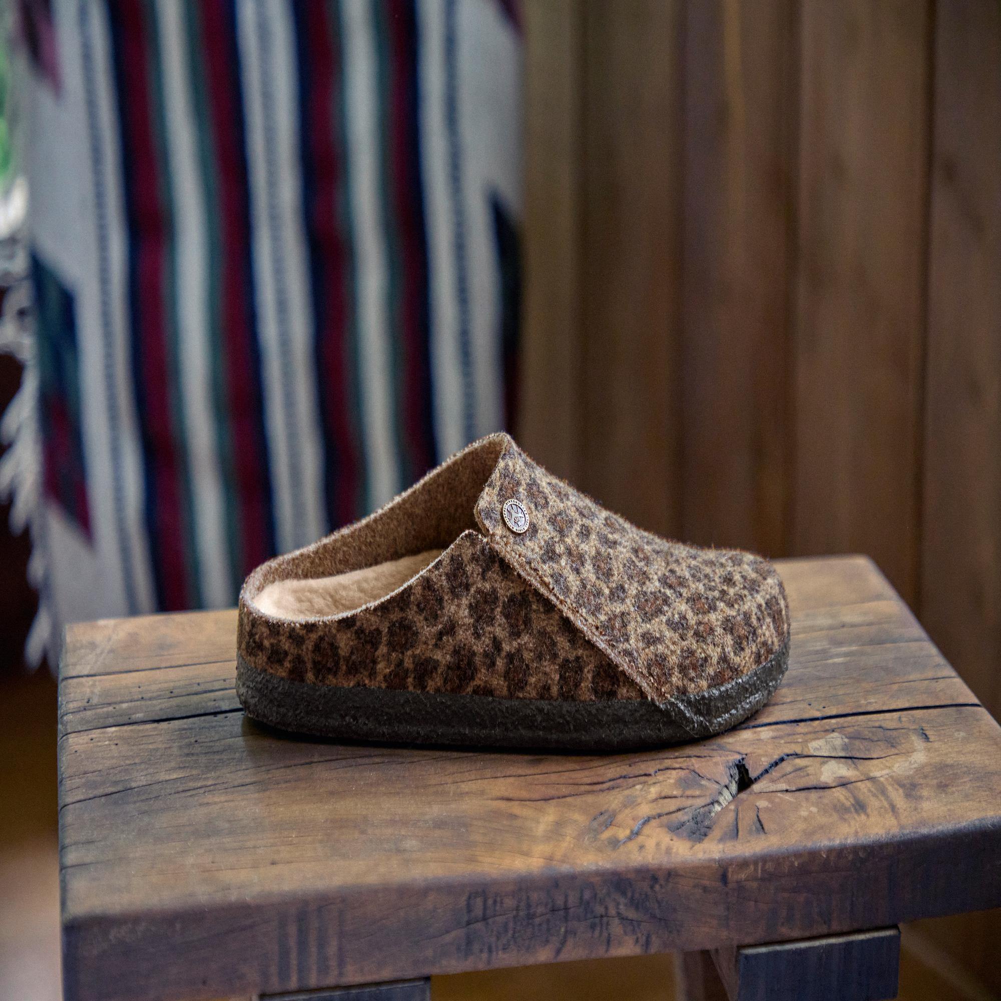 Birkenstock Zermatt leopard shearling slip-on mule with textile upper and arch support, placed on wooden surface.