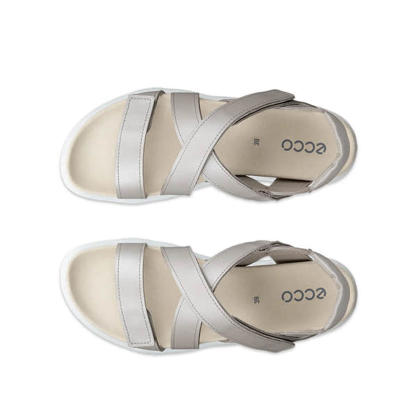 Pair of beige sandals with silver straps on a white background