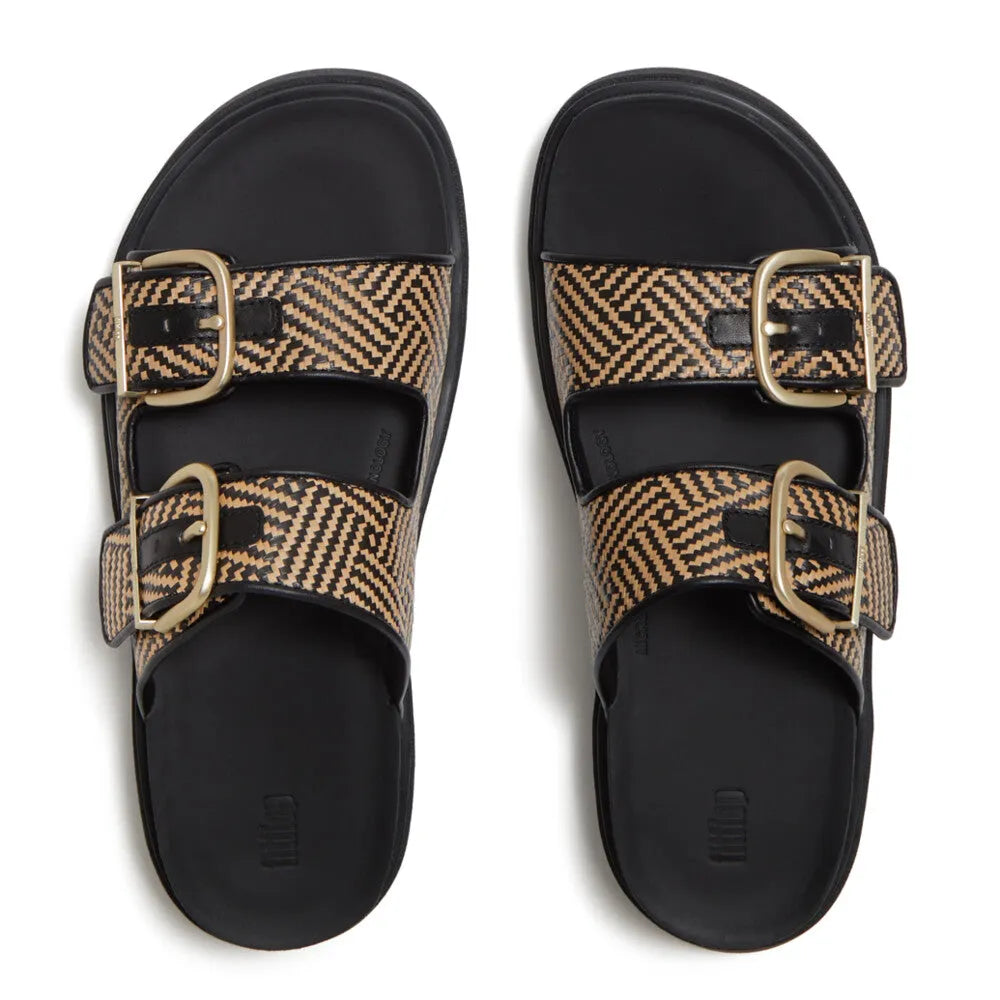 FitFlop women’s black leather and textile buckle slip-on sandals with geometric patterned straps and gold buckles.