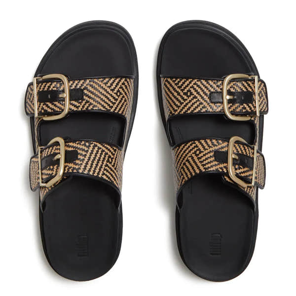 FitFlop women’s black leather and textile buckle slip-on sandals with geometric patterned straps and gold buckles.