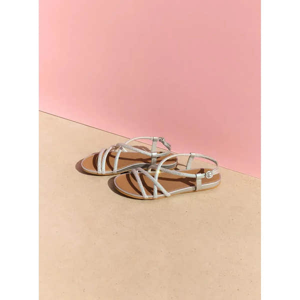 FitFlop Gracie Crystal ladies silver leather and textile sling-back sandals on beige surface with pink background.