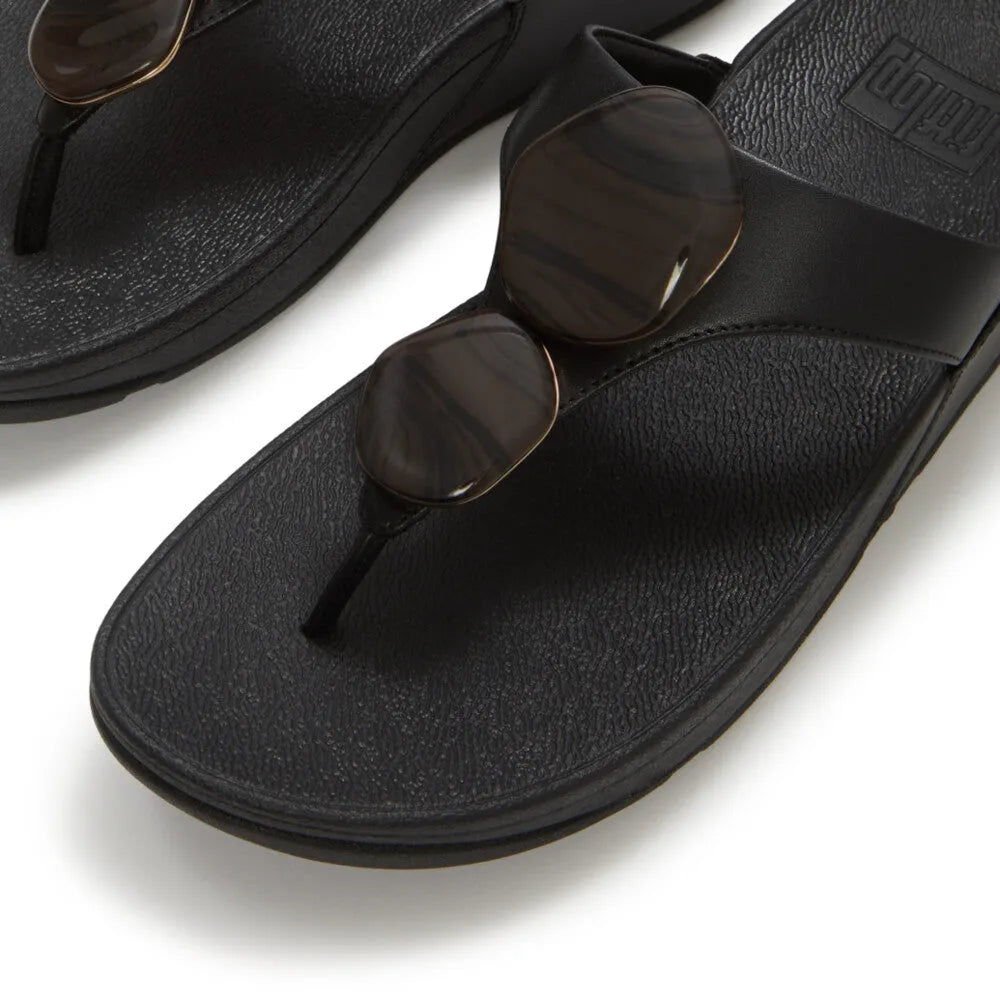 FitFlop Lulu Marbled Stone black T-bar sandals for women with slip-on design and rounded striped sunglasses.