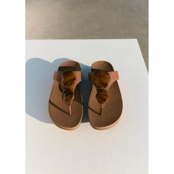 FitFlop Lulu marbled stone T-strap sandals for women, deep tan color with striped marble pattern on straps.