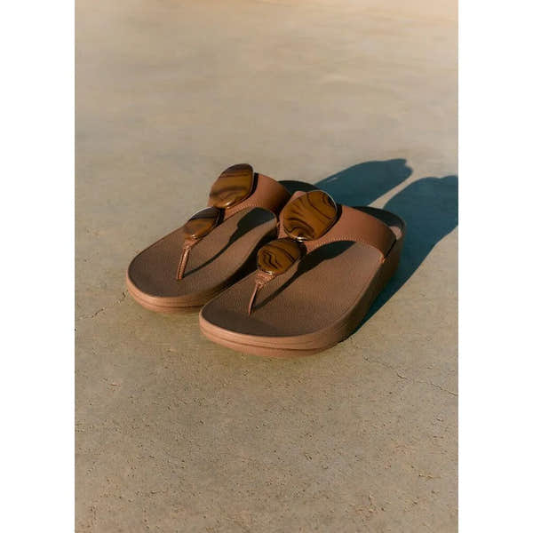FitFlop Lulu Marbled Stone women's tan T-strap sandals with oversized tortoise shell sunglasses detail.