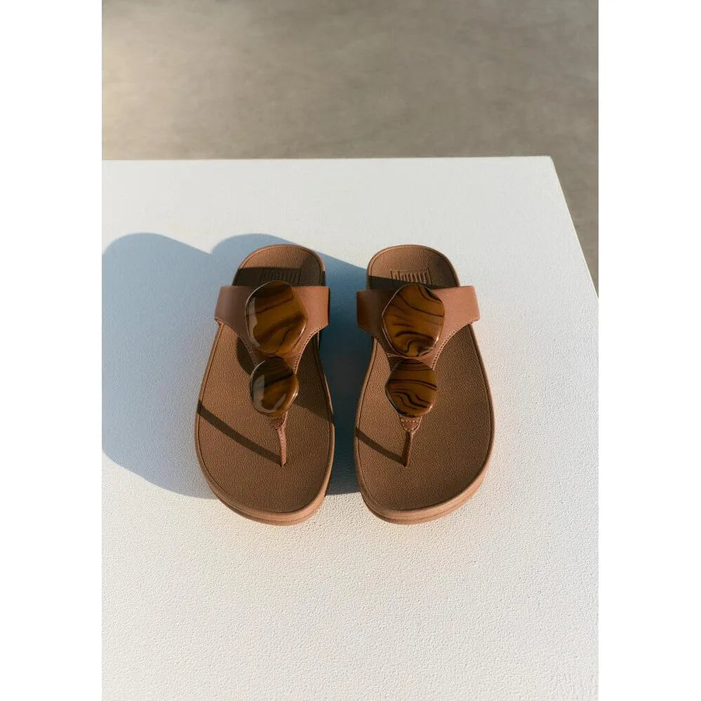 FitFlop Lulu marbled stone women's deep tan T-strap sandals with large circular buckle design.