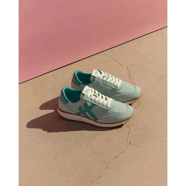 FitFlop Retro-Q FF ladies mint/teal leather and textile lace-up trainers on beige surface with pink background.