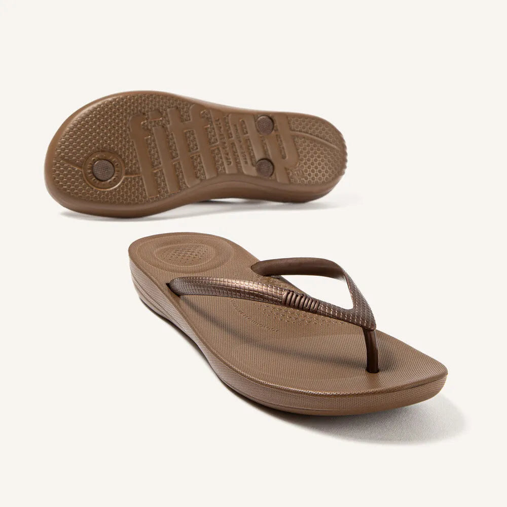 FitFlop E54-012 Iquishion Ladies Bronze T-bar Sandals, lightweight slip-on flip-flops with cushioned sole and metallic bronze finish.