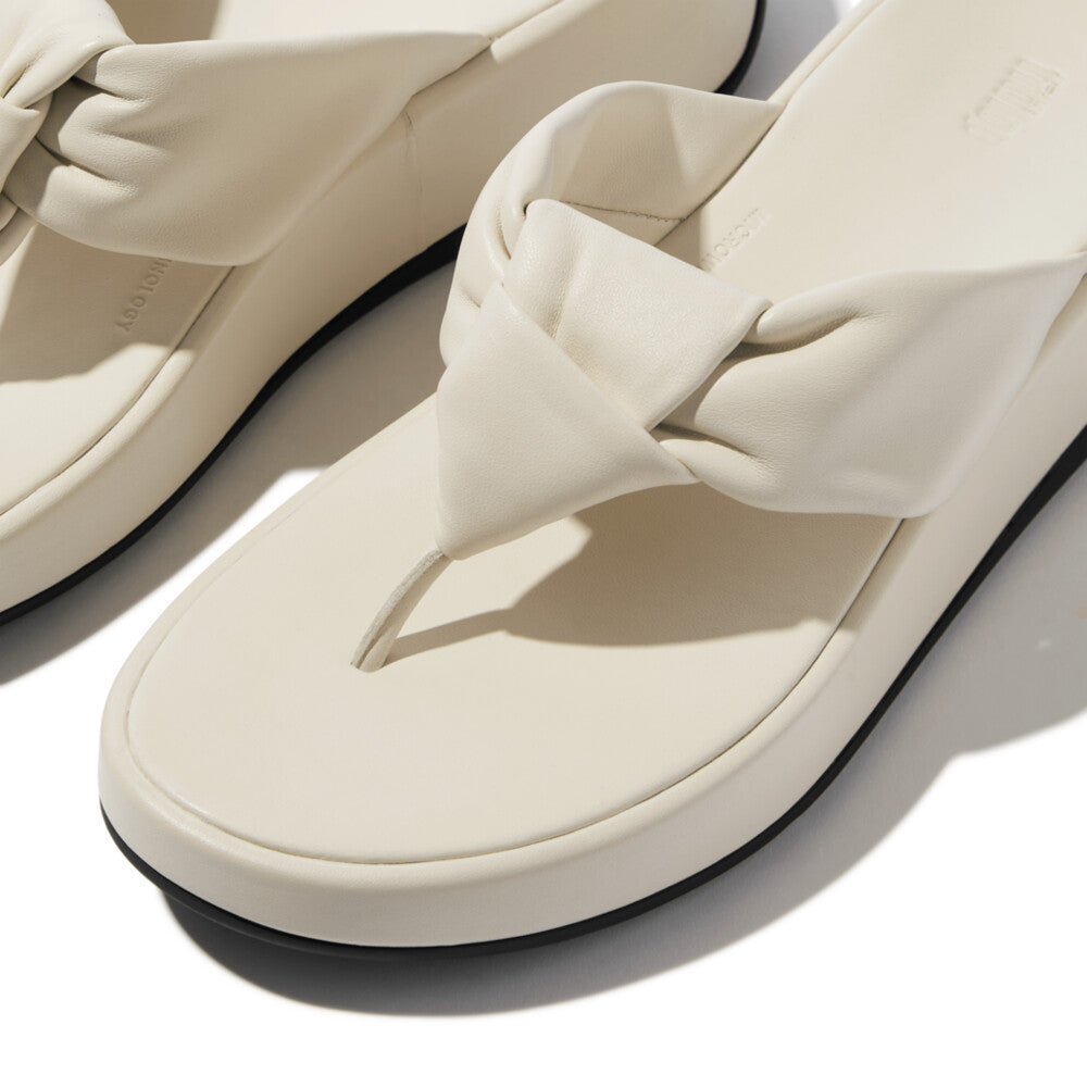 FitFlop F-Mode Knot beige leather slip-on sandals with twisted knot strap, cushioned footbed, and flat sole.