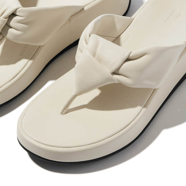 FitFlop F-Mode Knot beige leather slip-on sandals with twisted knot strap, cushioned footbed, and flat sole.