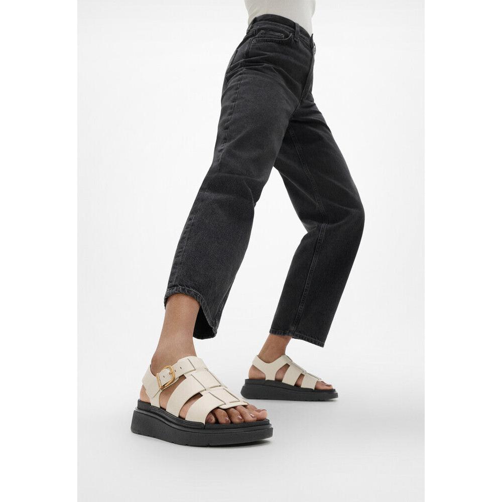 FitFlop IZ1-A99 Gen-FF women's wide beige leather buckle sandals with chunky black soles.