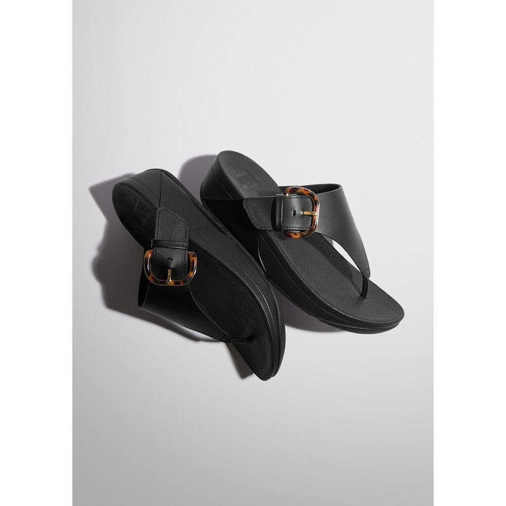 FitFlop Lulu Resin Ladies Black Leather Slip-On Sandals with decorative tortoise shell buckles.