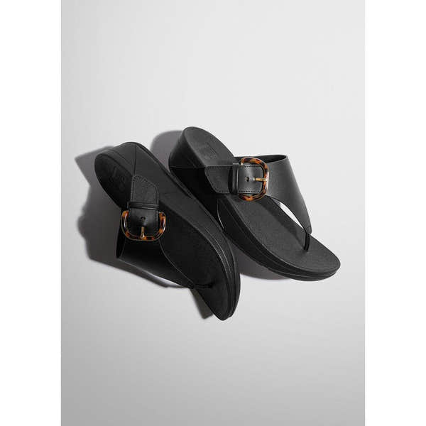 FitFlop Lulu Resin Ladies Black Leather Slip-On Sandals with decorative tortoise shell buckles.