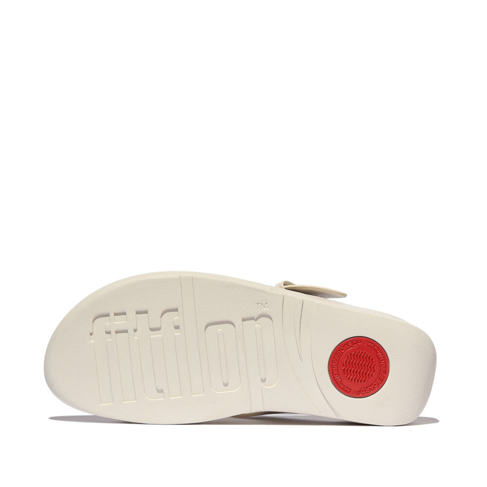 FitFlop Lulu Resin beige leather slip-on sandals with cushioned sole and red circular rubber grip detail.