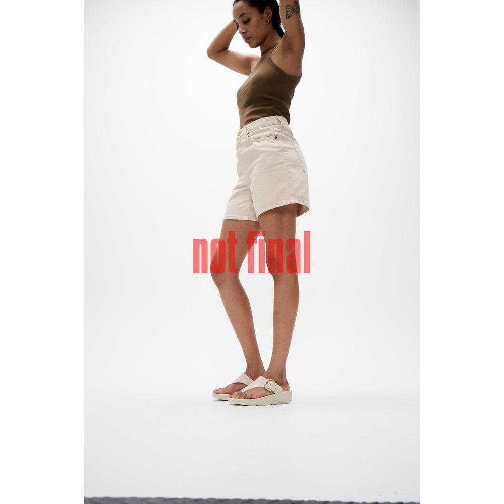 FitFlop Lulu Resin beige leather slip-on sandals worn by a woman in casual outfit.