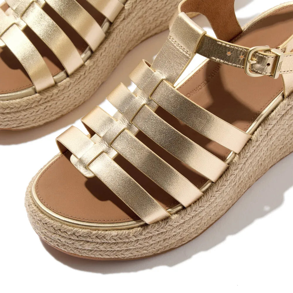 FitFlop JF5-675 platform espadrille sandals with gold leather T-strap, adjustable ankle strap, and woven wedge sole.