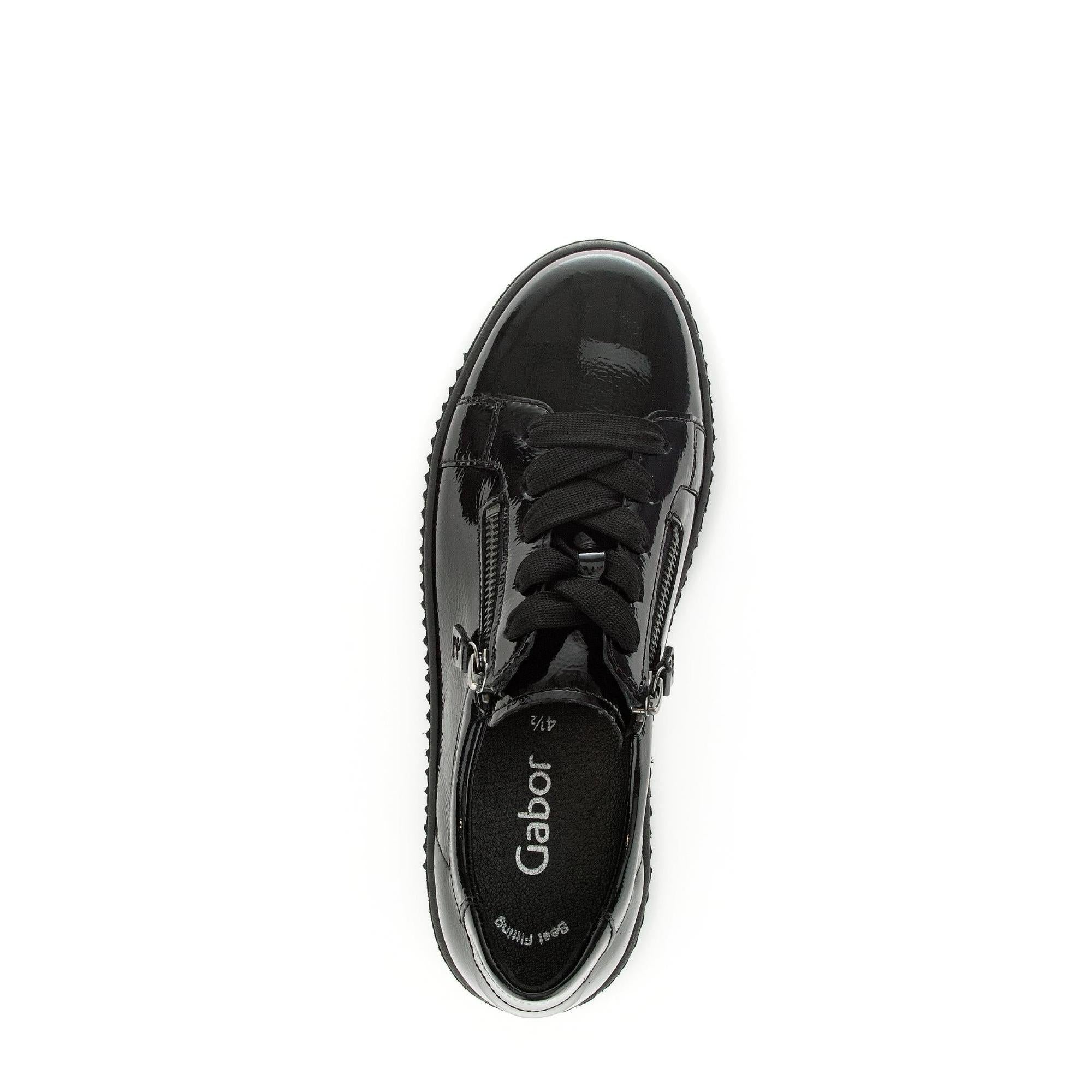 Black patent leather ladies' trainers with lace-up and zip closures, featuring a chunky sole and branded interior.