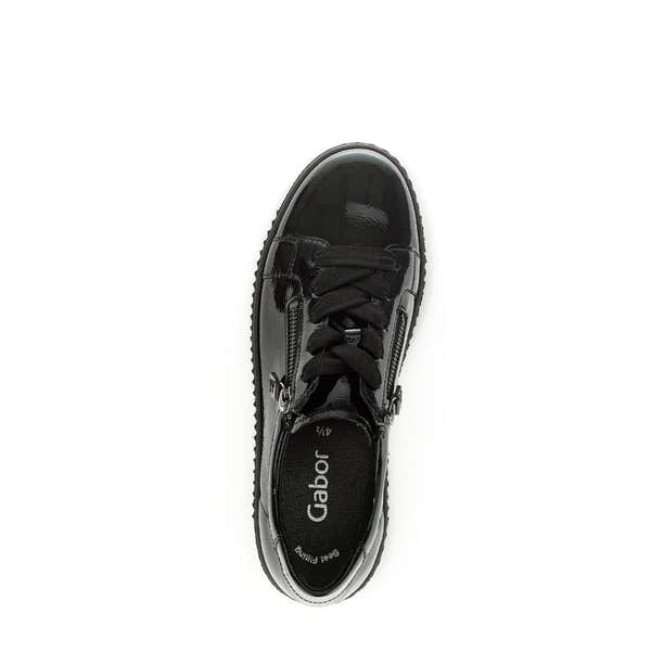Black patent leather ladies' trainers with lace-up and zip closures, featuring a chunky sole and branded interior.