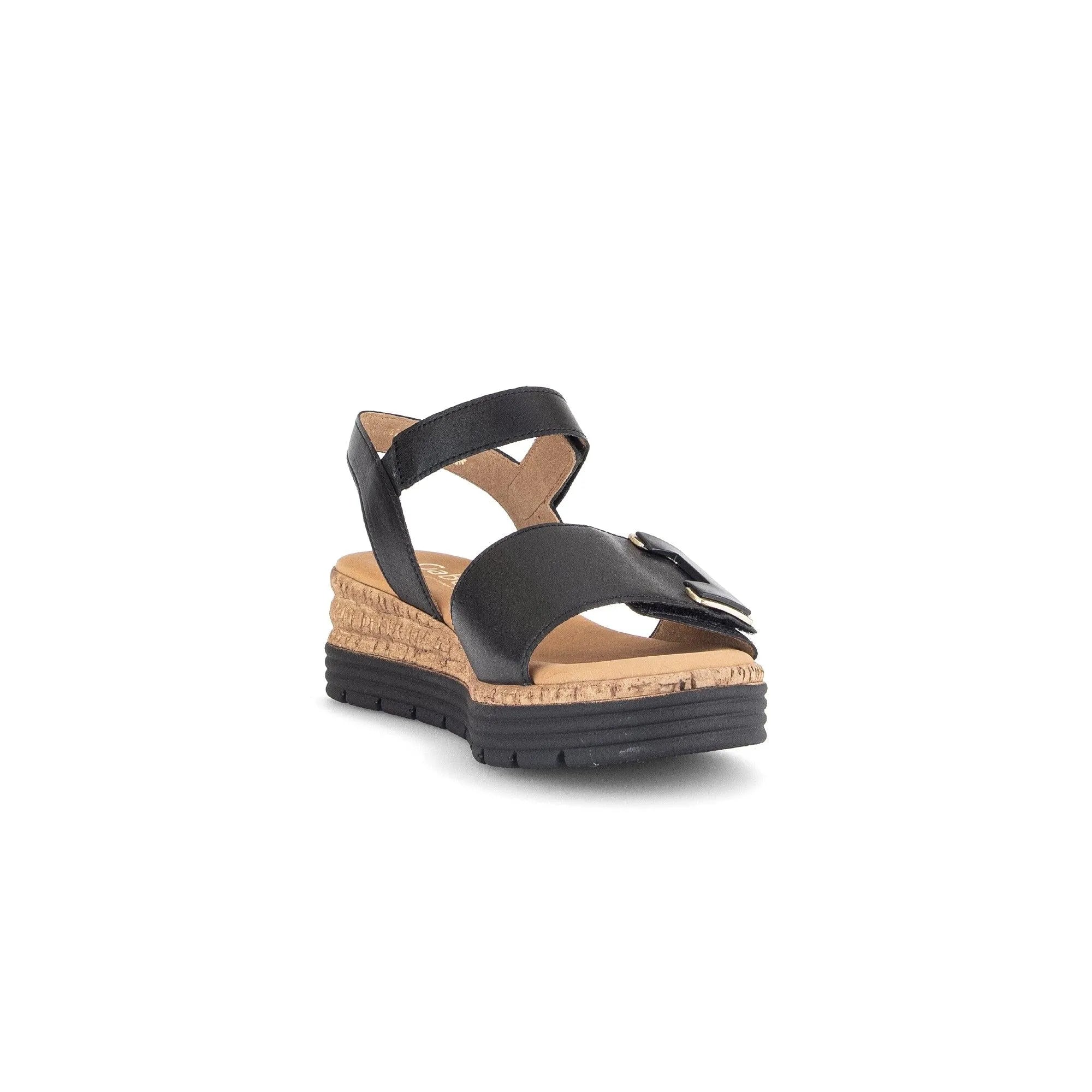 Black leather women's sandal with touch-fastening straps, gold-tone buckle details, cork wedge heel, and black rubber outsole.
