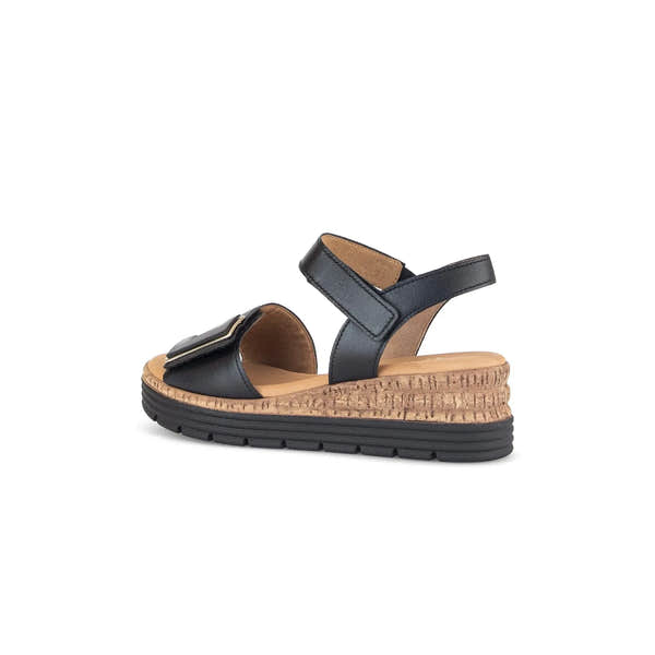 Stylish black leather sandals with touch fastening and a cork wedge heel, featuring a comfortable sole and adjustable straps.