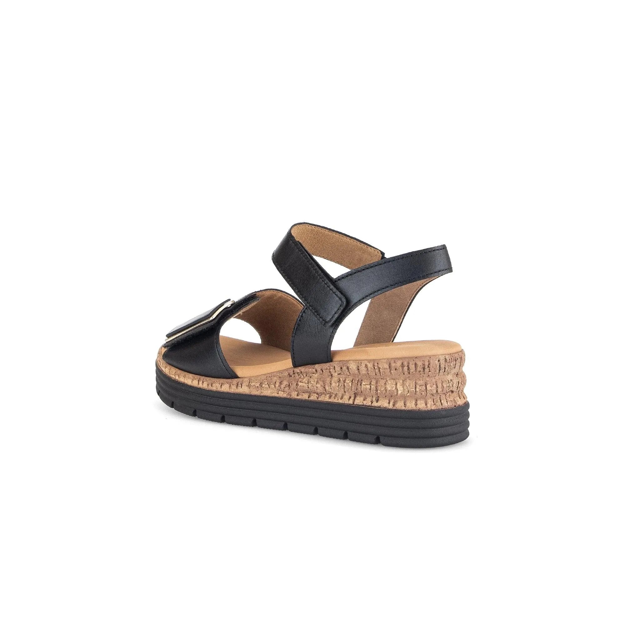 Black leather ladies' sandal with touch fastening, cushioned insole, and wedge cork and rubber sole.
