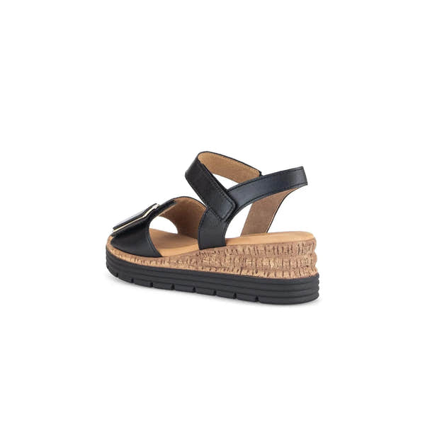 Black leather ladies' sandal with touch fastening, cushioned insole, and wedge cork and rubber sole.