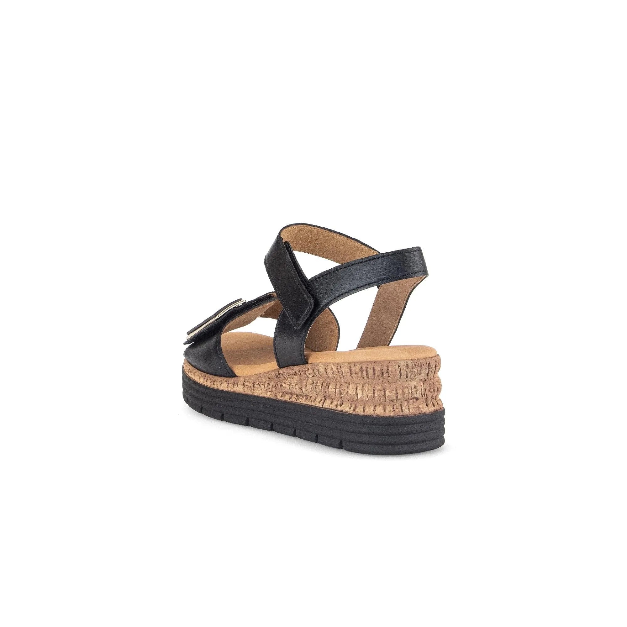 Black leather sandals with touch fastening, cork wedge heel, and cushioned footbed for comfort. Stylish and versatile design.