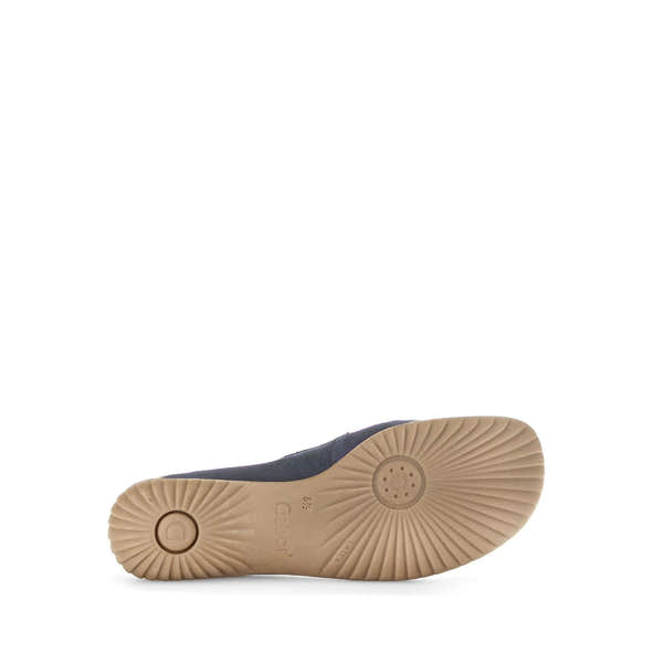 Blue nubuck slip-on shoes with beige rubber soles featuring textured grip and circular design, stylish and comfortable.