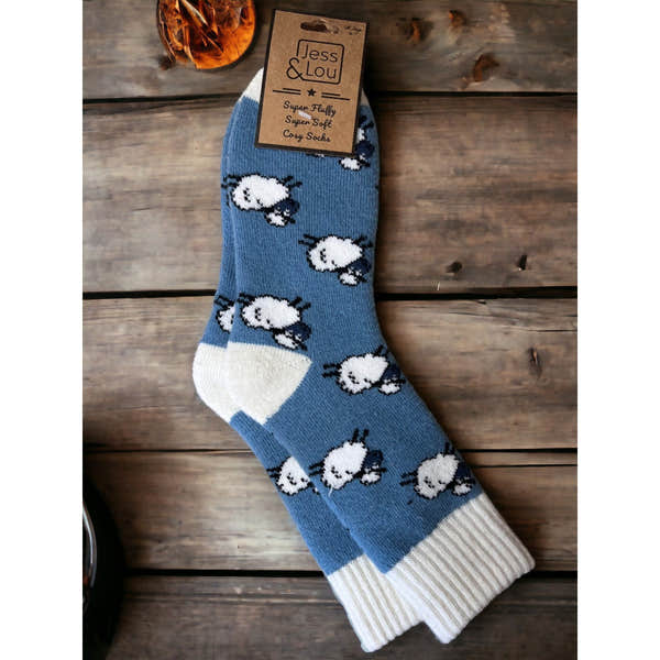Jess & Lou Shaggy Sheep Ribbed Cornflower Socks with white toe and heel, featuring a playful sheep pattern on blue background.