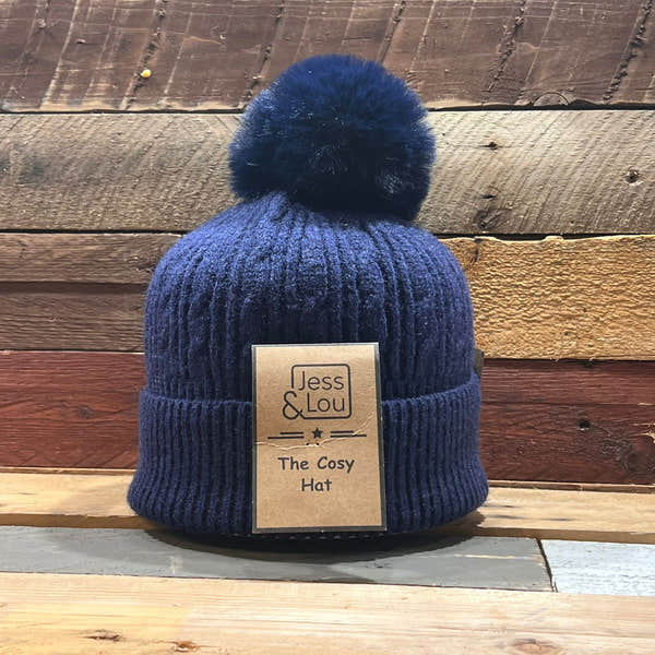 Unisex navy cable knit bobble hat with a fluffy pom-pom, featuring a folded brim and Jess & Lou branding.